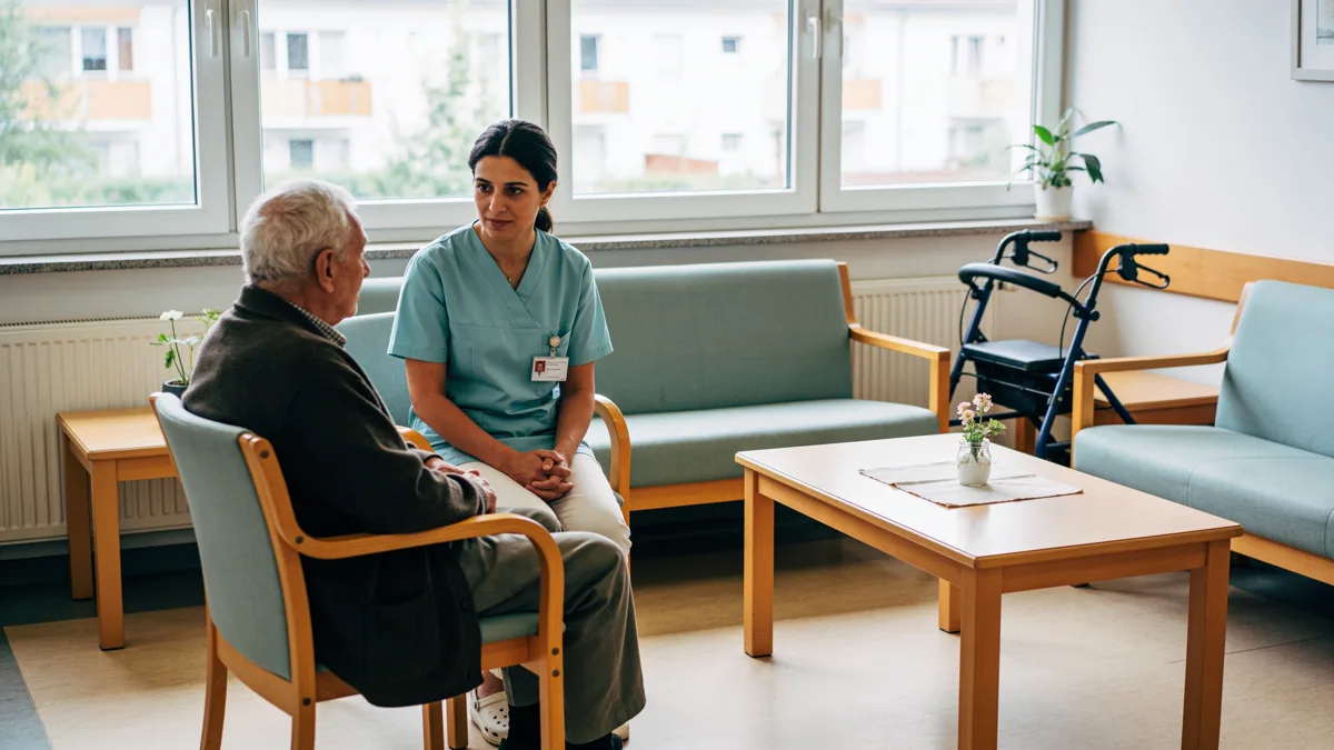 Pflegekraft im Gespräch mit einer älteren Person